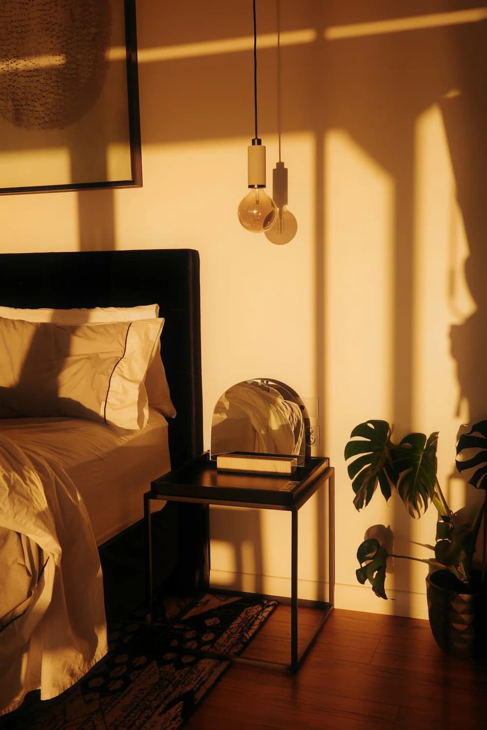 A warm bedside lamp glowing at golden hour beside a nightstand.