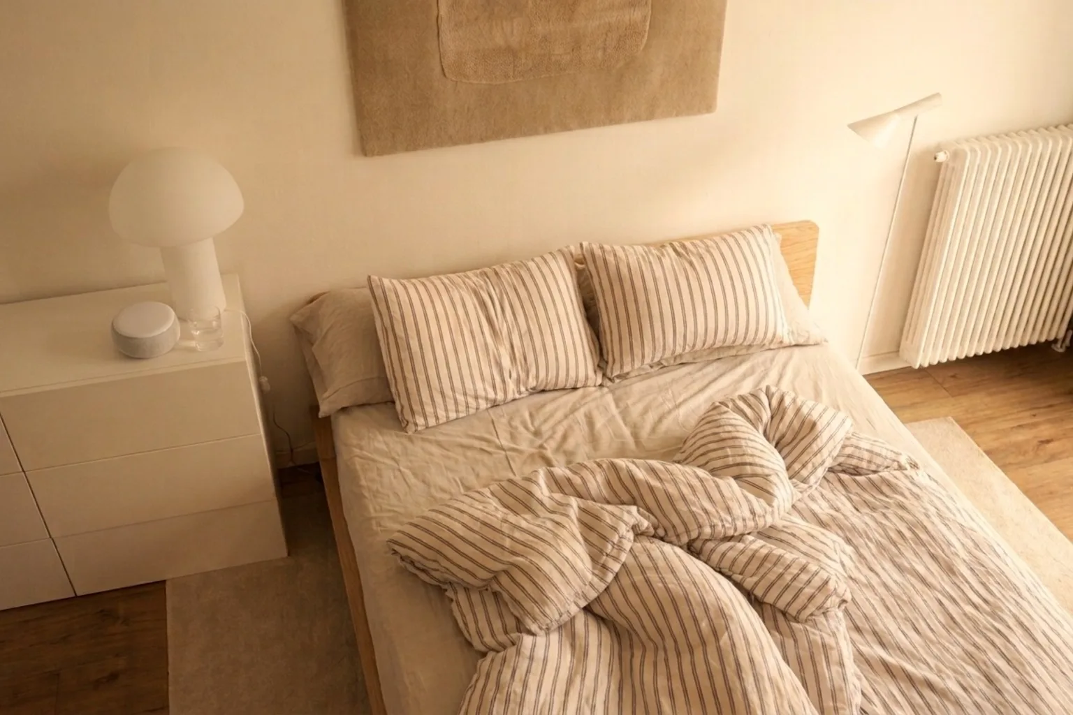 Morning light filling a bedroom as someone rests in bed.